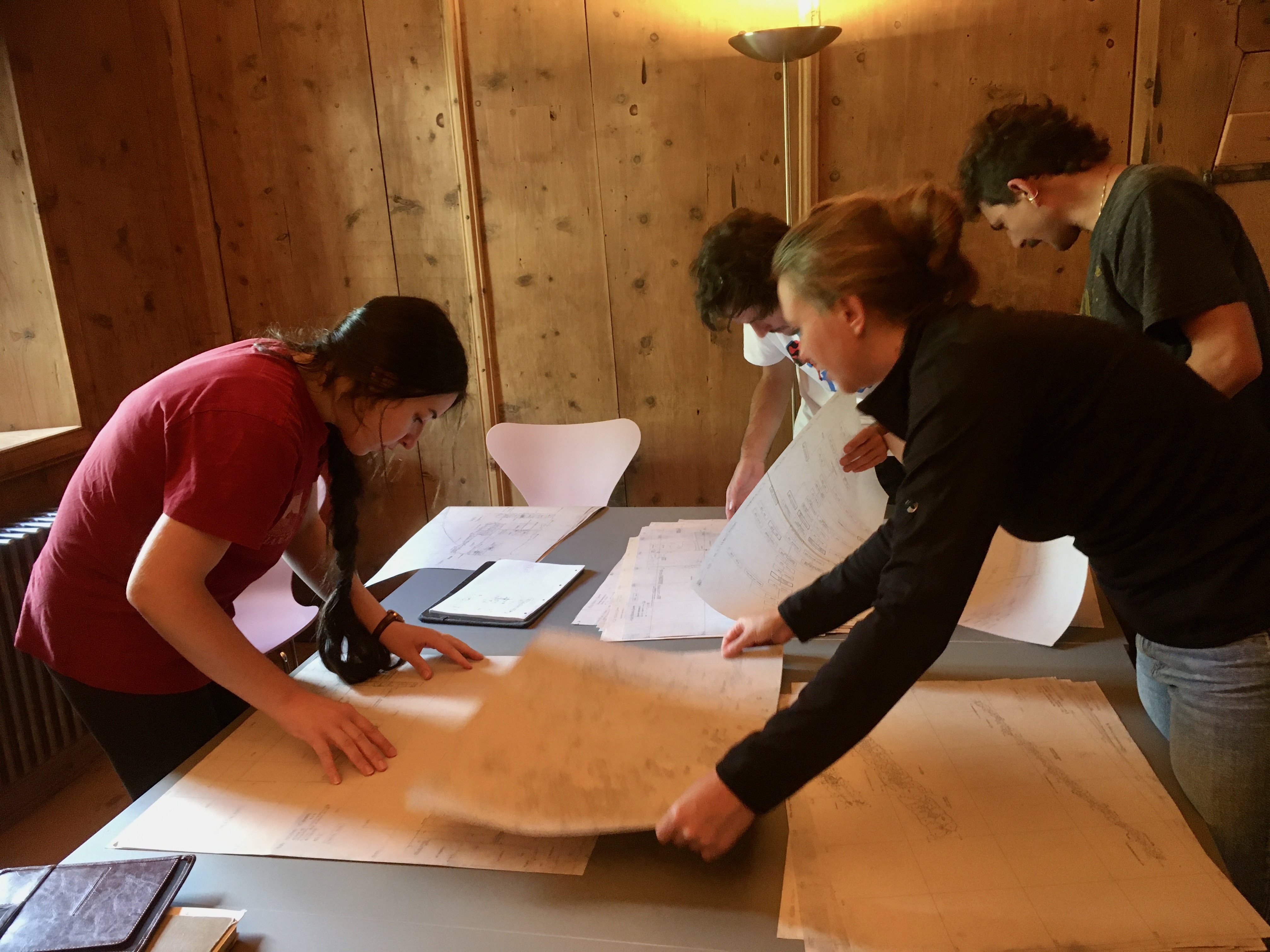 Die „Pfostenloch-Gruppe“ beim Zusammenstellen der relevanten Plana. V.l.n.r.: Cristina Rimoldi, Maurus Camenisch, Melina Kuchling, Lukas Dörig (Foto: Carola Jäggi)