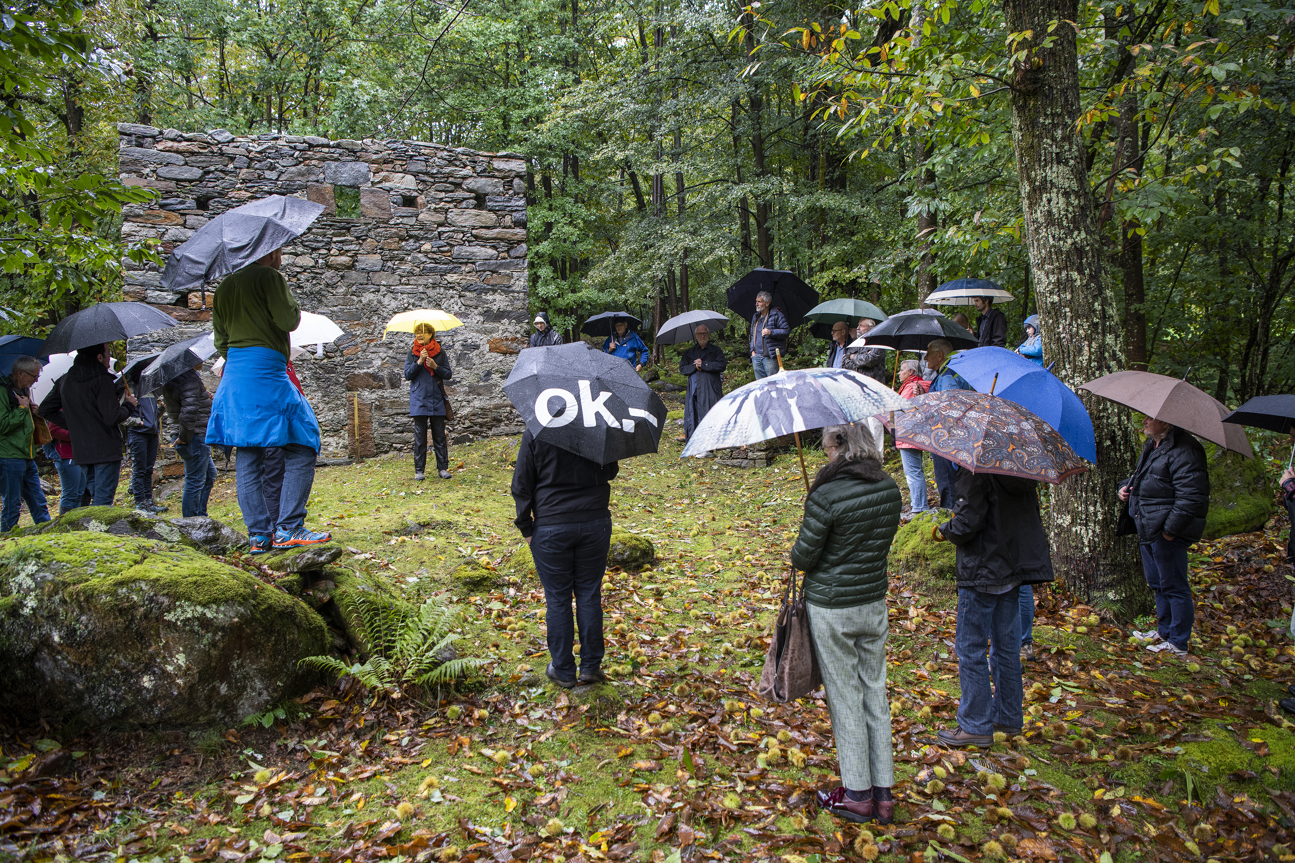 Kurzansprache von Prof. Dr. Carola Jäggi bei strömendem Regen vor dem Steinhaus von Casnàcc